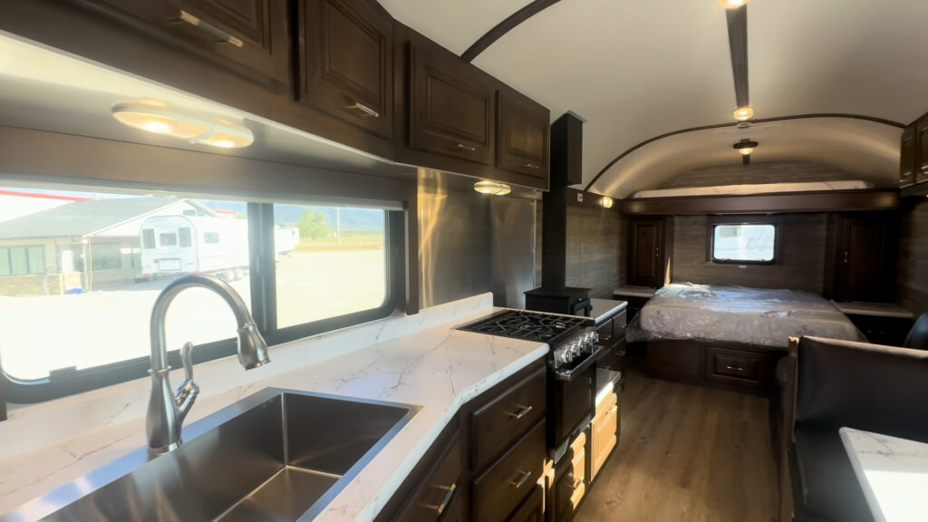 Interior view from the Kendall Camp kitchen past the stove toward the queen bed and rear window.