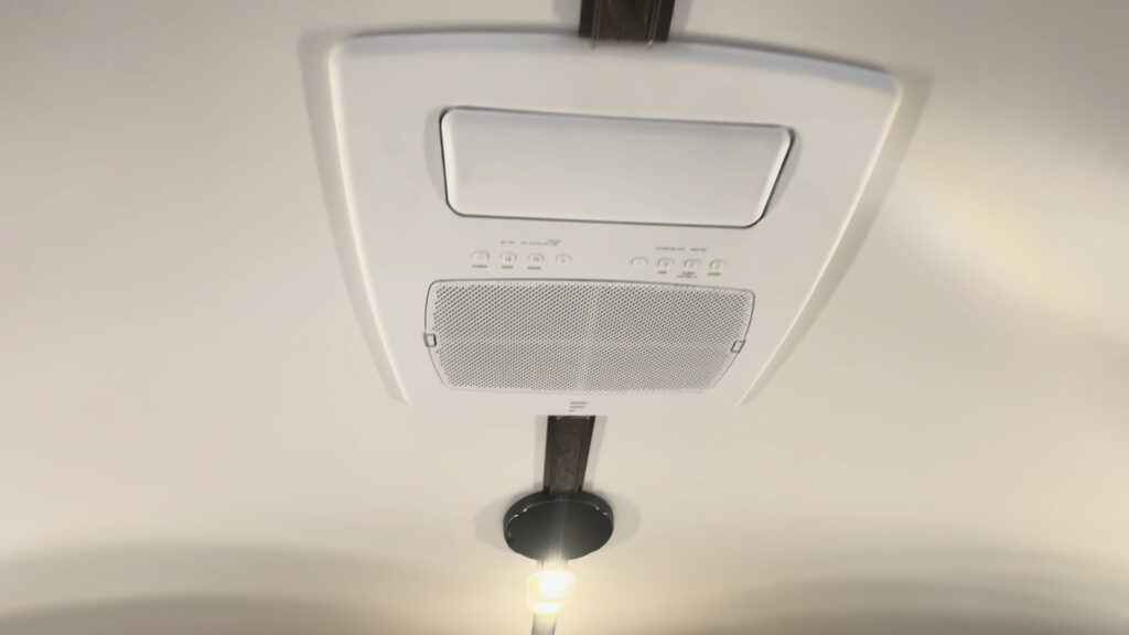 Upward interior view of the Kendall Camp ceiling-mounted air-conditioning unit and nearby light.