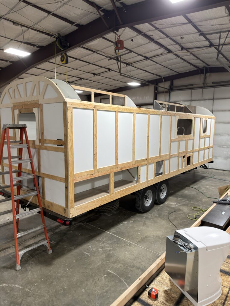Peak camp wall framing and insulated panels under construction in the workshop