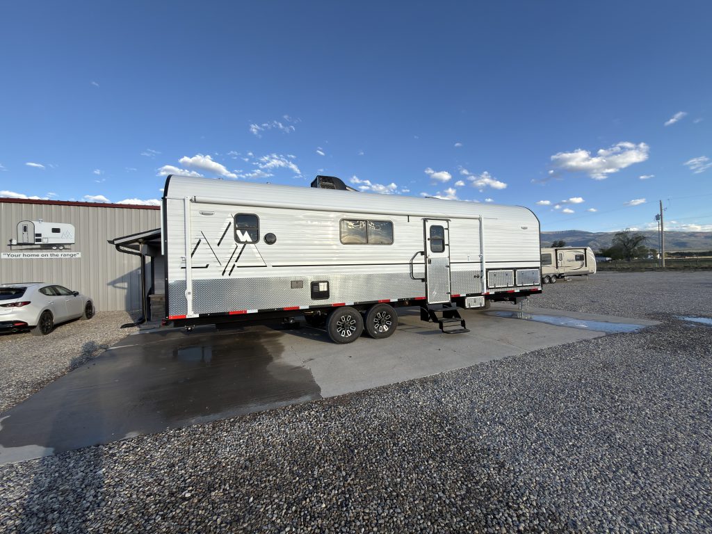 Wide side view of the camp on a gravel lot in Keulen Camp #132.