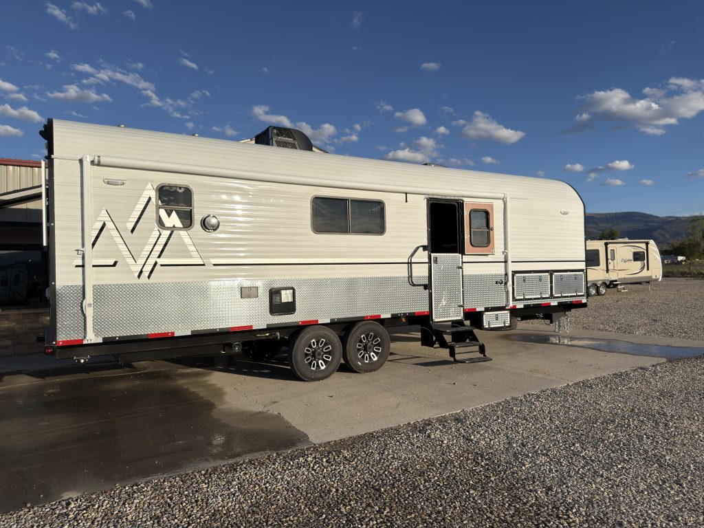 Full side profile showing windows, Peak graphics, and tandem wheels in Keulen Camp #132.