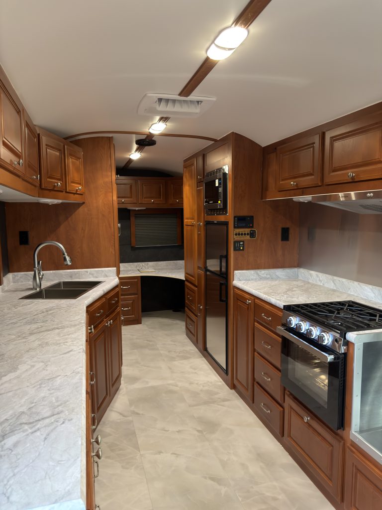 Wood cabinets, sink, and range along the main interior aisle in Keulen Camp #132.