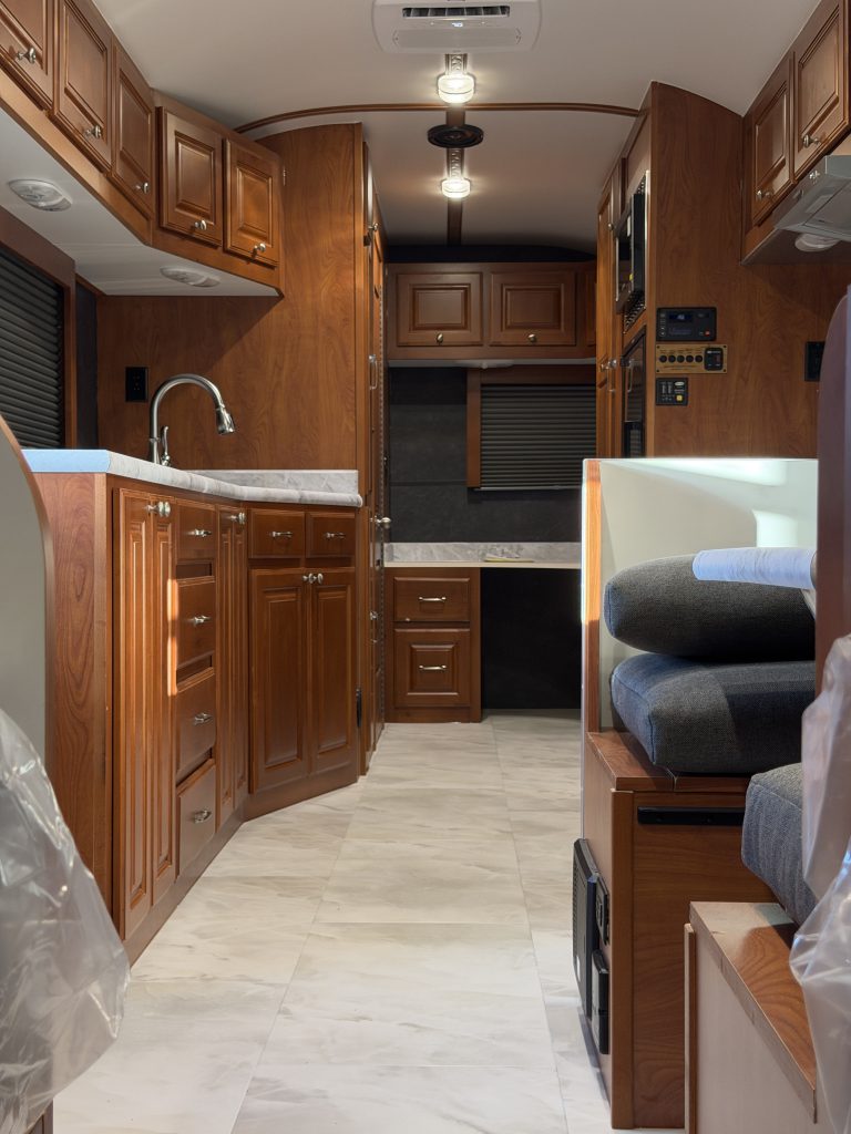 View down the aisle toward the sink, cabinetry, and refrigerator in Keulen Camp #132.