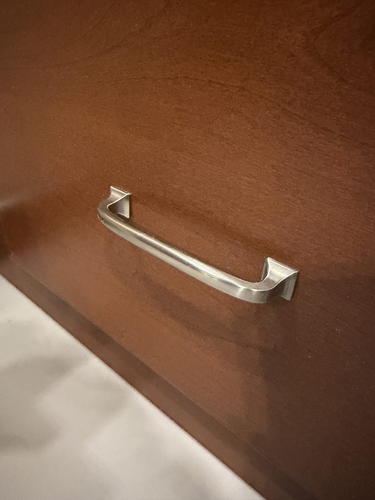 Metal pull handle on a wood drawer front in Keulen Camp #132.