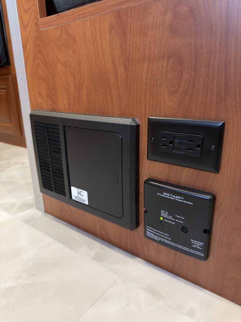 Electrical enclosure and control panels mounted on the side of the dinette bench in Keulen Camp #132.