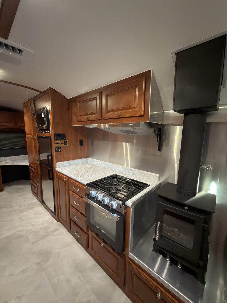 Kitchen range, wood stove, upper cabinets, and countertop in Keulen Camp #132.