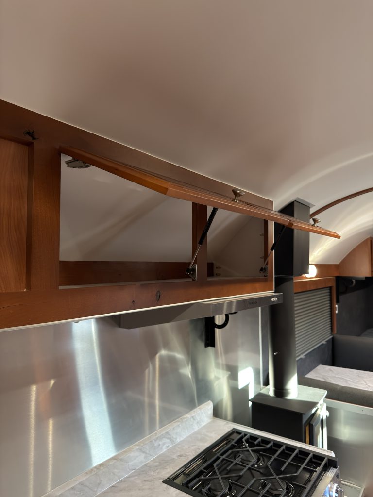 Open overhead storage above the kitchen range in Keulen Camp #132.