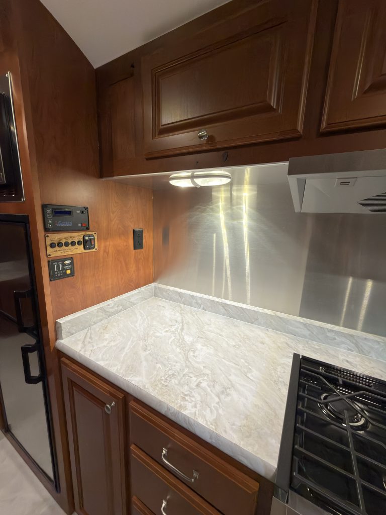 Countertop with metal backsplash, drawers, and overhead cabinetry in Keulen Camp #132.