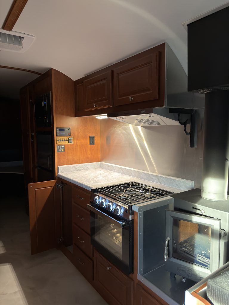 Range and wood cabinetry along the kitchen aisle in Keulen Camp #132.