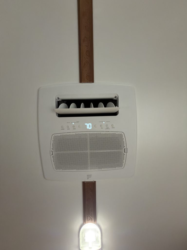 Ceiling-mounted air conditioner and nearby light in Keulen Camp #132.