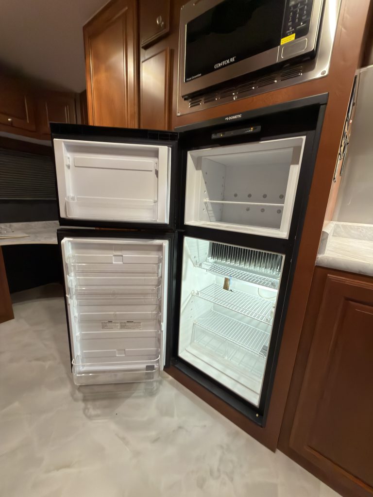 Refrigerator and freezer doors open to show shelves and compartments in Keulen Camp #132.