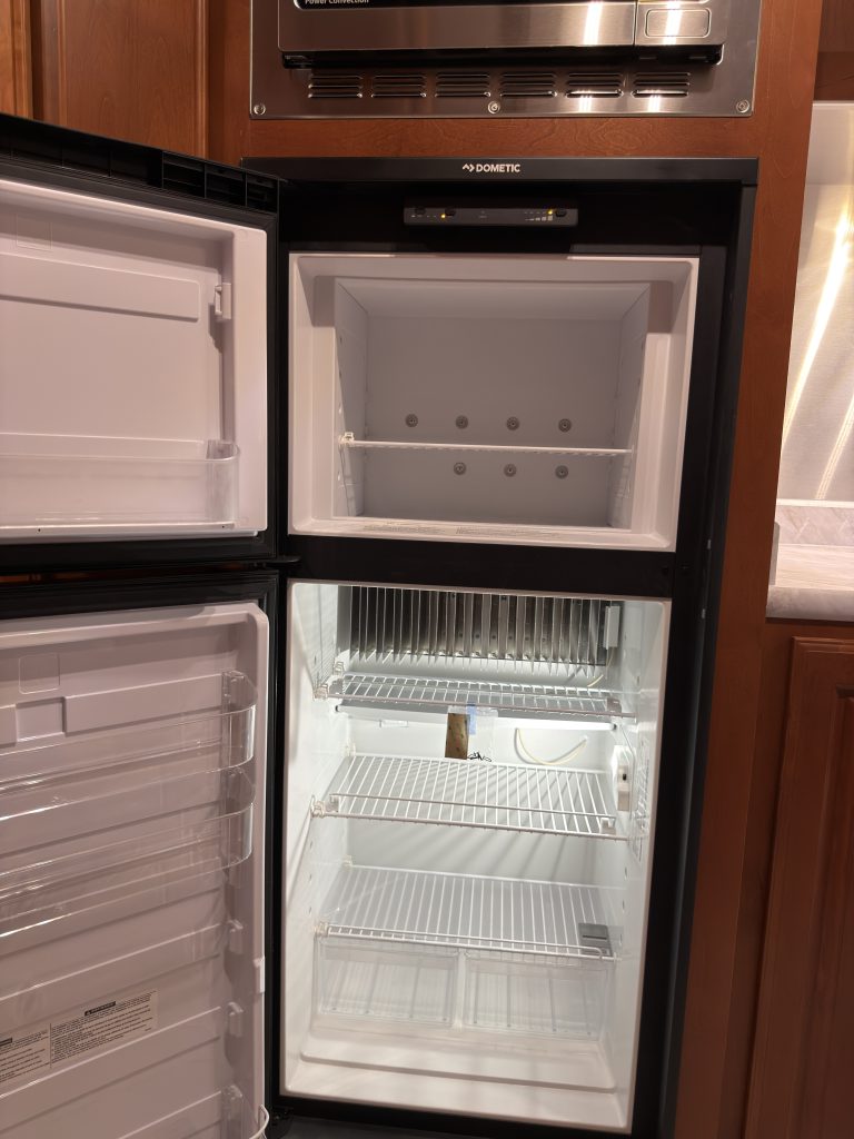 Closer view of open refrigerator and freezer compartments in Keulen Camp #132.