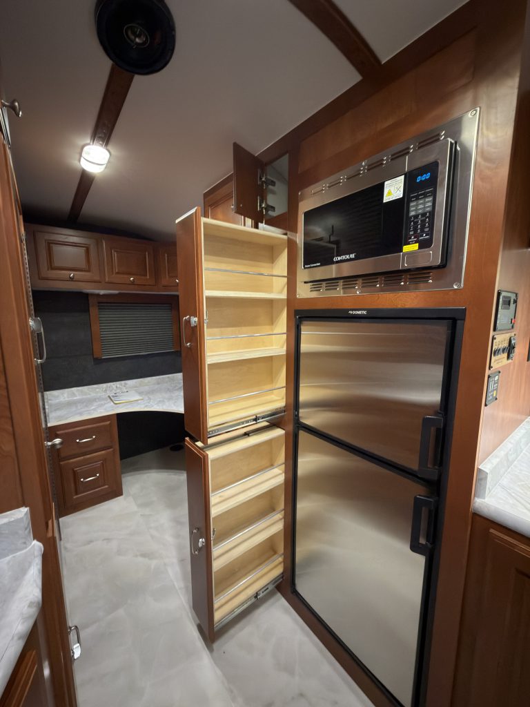 Two pull-out pantries open beside the refrigerator in Keulen Camp #132.