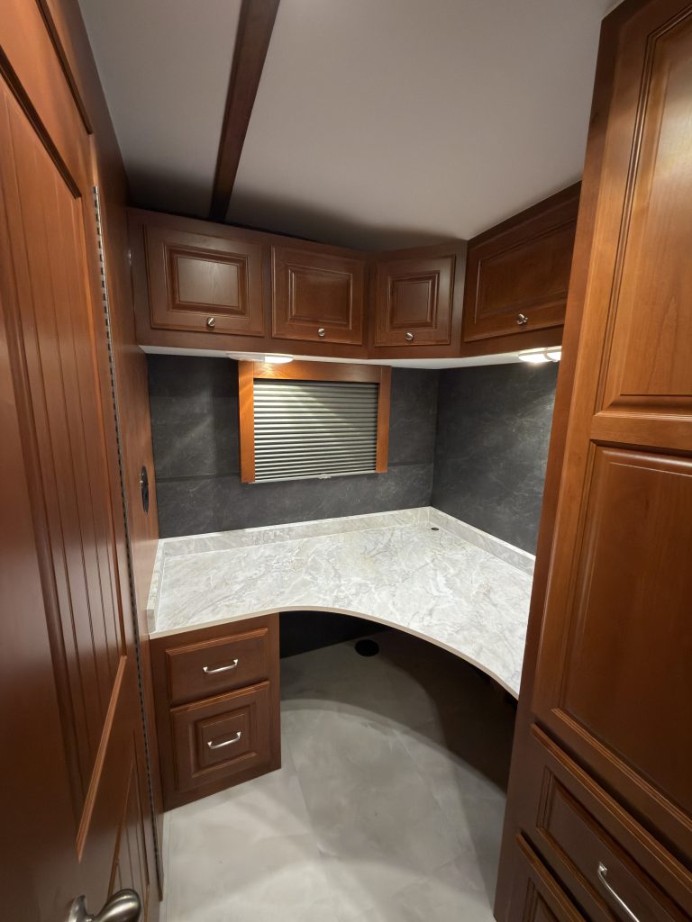 Corner desk with window, overhead cabinets, and drawers in Keulen Camp #132.