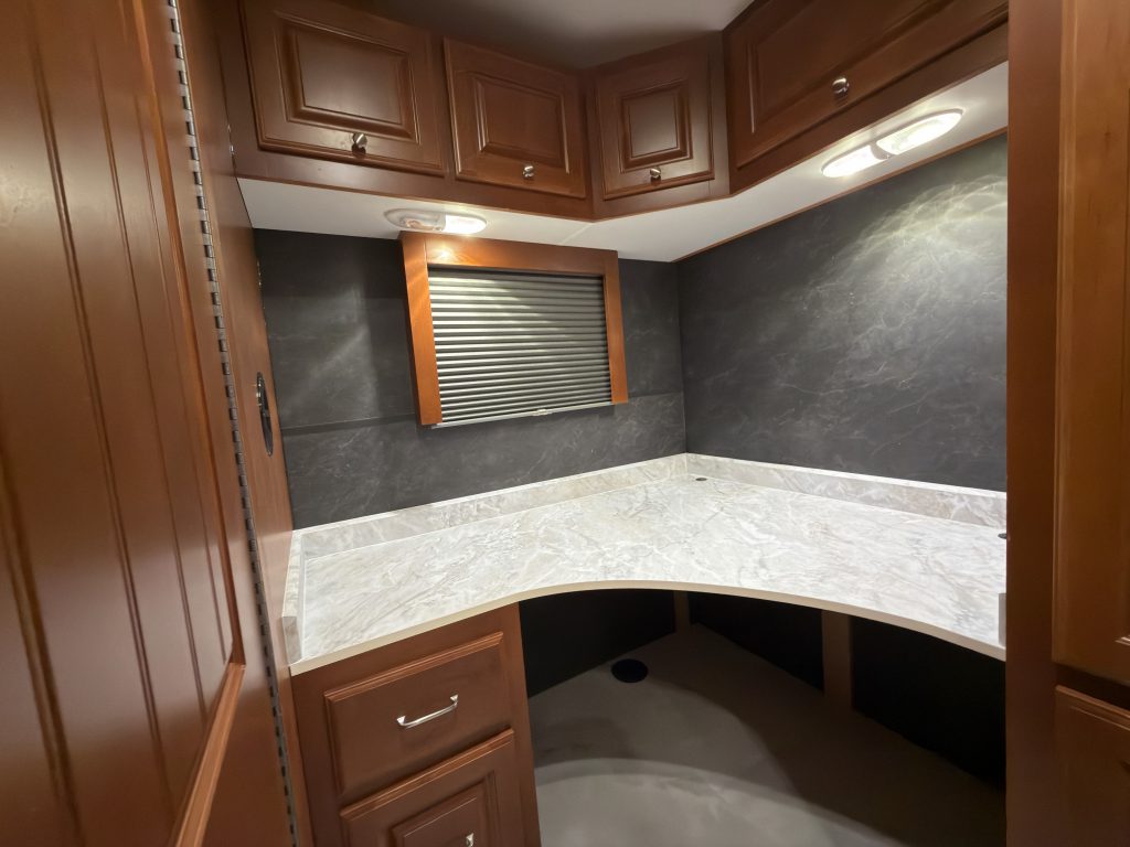 L-shaped desk beneath a window and overhead cabinets in Keulen Camp #132.