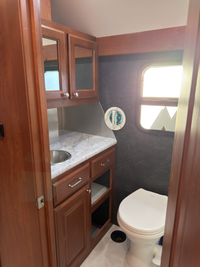 Vanity, toilet, and mirrored upper cabinets in Keulen Camp #132.