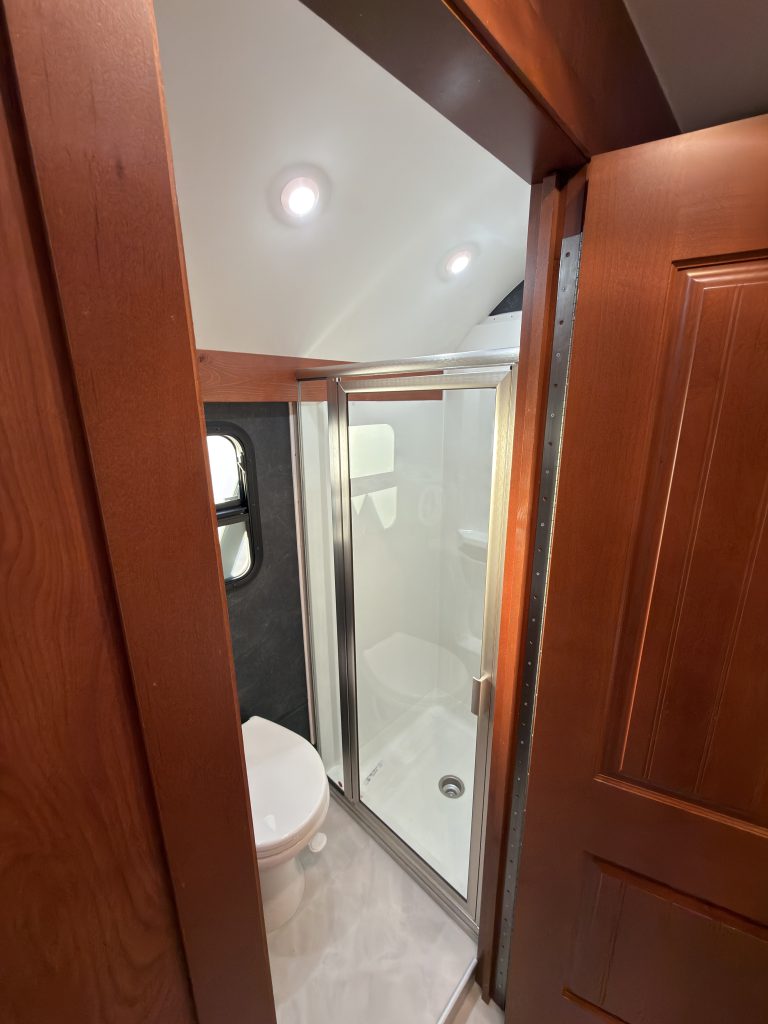 Open bathroom doorway beside a glass shower enclosure in Keulen Camp #132.
