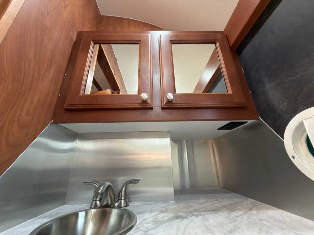 Mirrored cabinet doors above the bathroom sink in Keulen Camp #132.