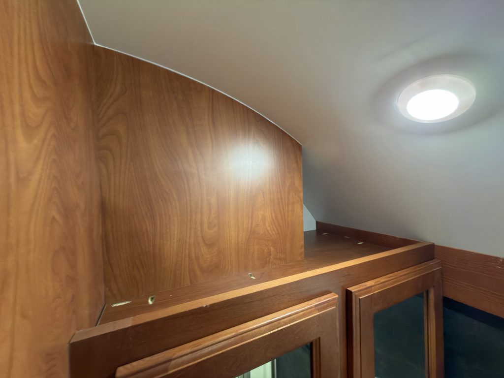 Wood cabinet trim beneath the curved bathroom ceiling in Keulen Camp #132.