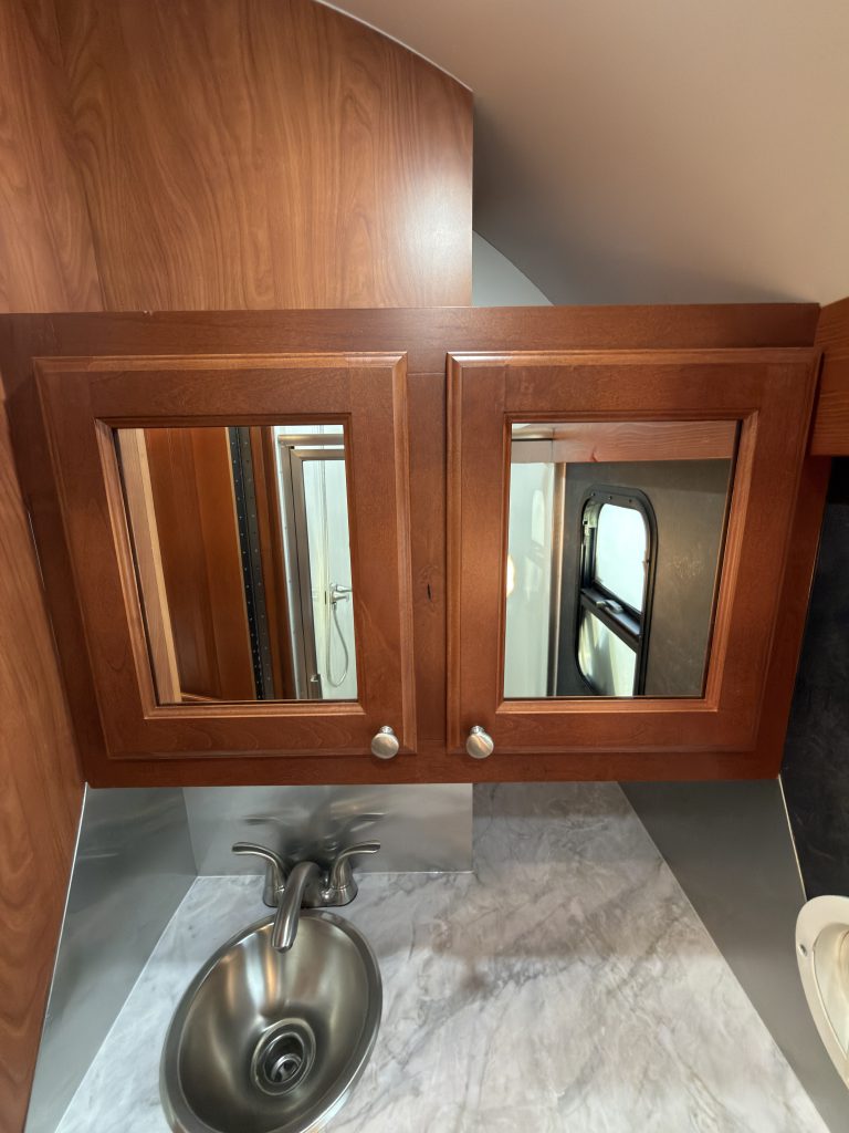 Closed mirrored cabinets above the round sink in Keulen Camp #132.