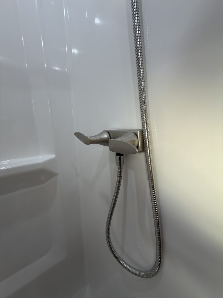 Close view of the shower mixer and handheld shower hose in Keulen Camp #132.