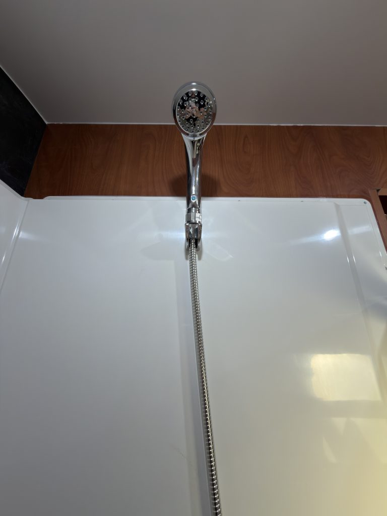 Handheld shower head mounted high on the shower wall in Keulen Camp #132.