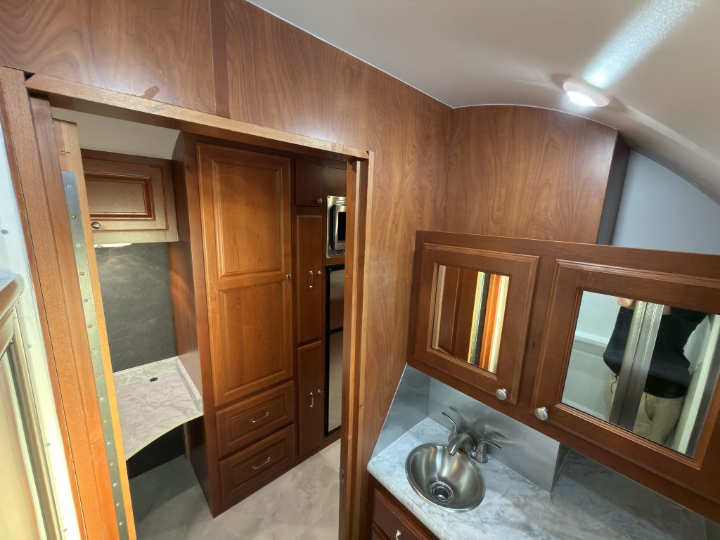 Bathroom vanity and mirrored cabinets beside the open door in Keulen Camp #132.