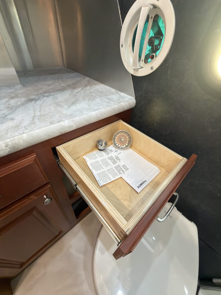 Bathroom vanity drawer extended beside the toilet in Keulen Camp #132.