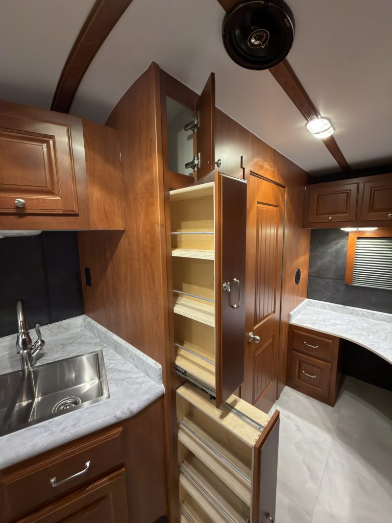 Additional pull-out pantries open beside the kitchen sink in Keulen Camp #132.
