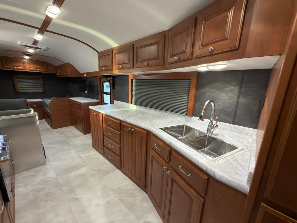 Long counter with double sink, drawers, overhead cabinets, and window in Keulen Camp #132.