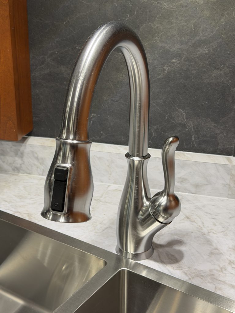 Tall curved kitchen faucet with pull-down head and single handle in Keulen Camp #132.
