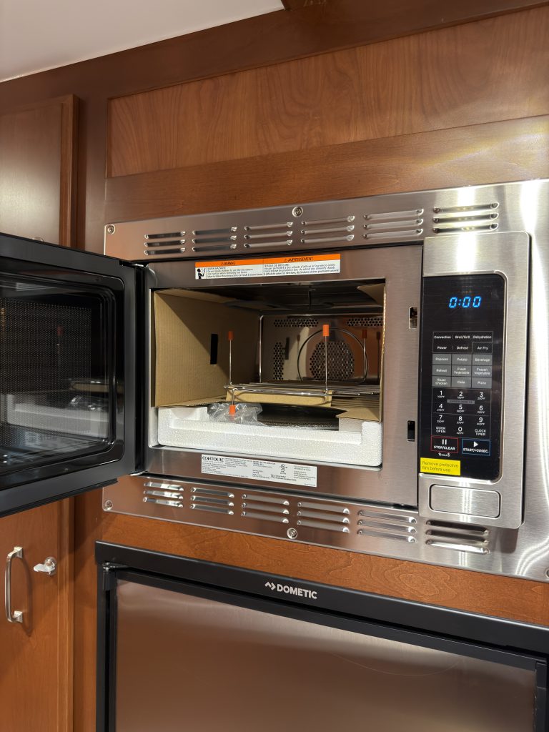 Open microwave showing the cooking cavity and turntable in Keulen Camp #132.