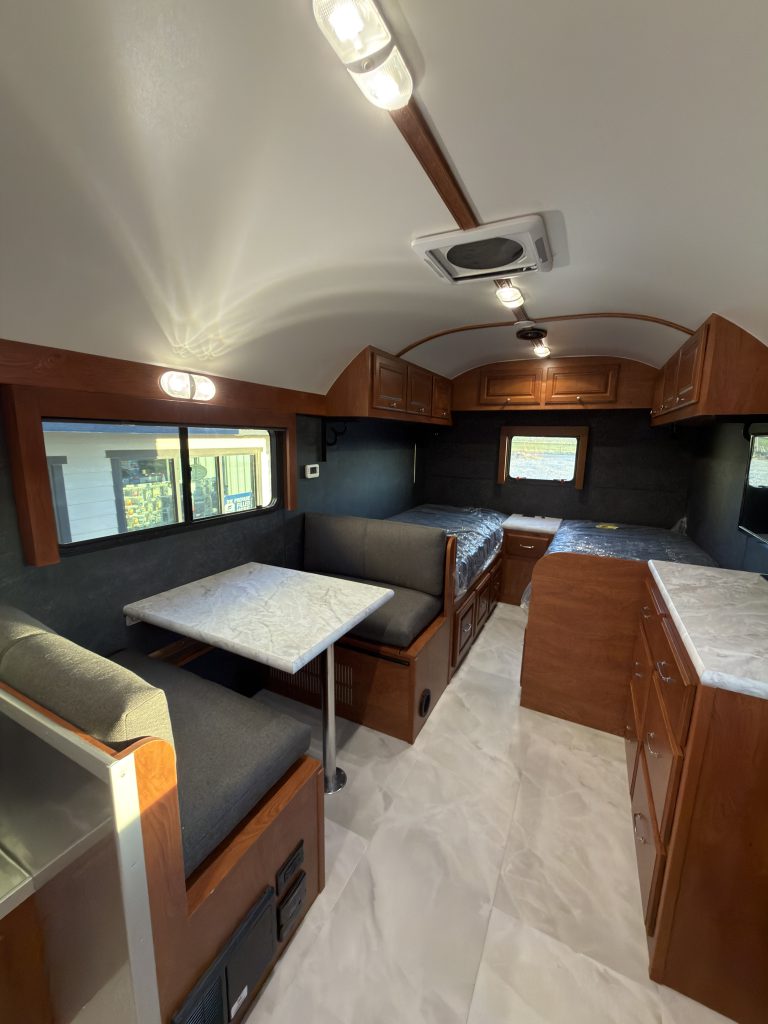 Dinette table and twin mattress platforms with uncovered windows in Keulen Camp #132.