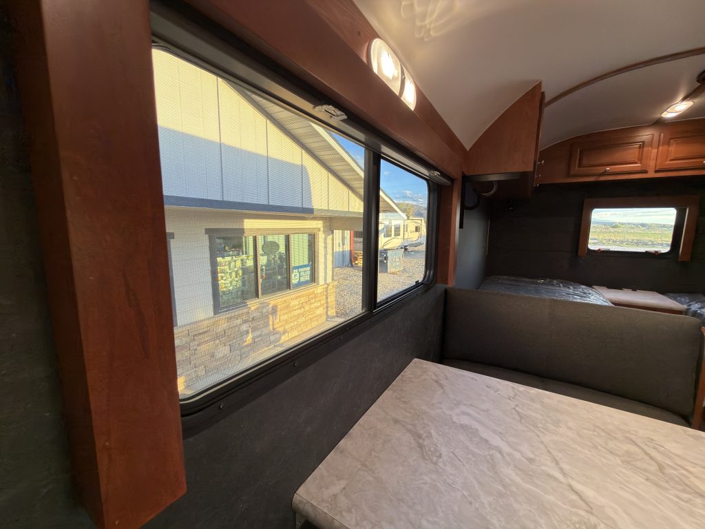 Dinette tabletop and seating beneath a wide uncovered window in Keulen Camp #132.
