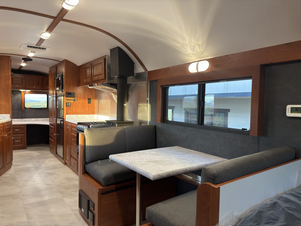Upholstered dinette with tabletop beneath a window beside the kitchen in Keulen Camp #132.