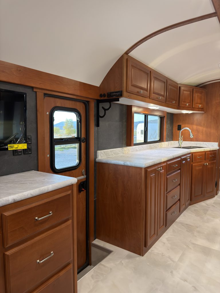 Wood-trimmed entry door beside the long kitchen countertop in Keulen Camp #132.