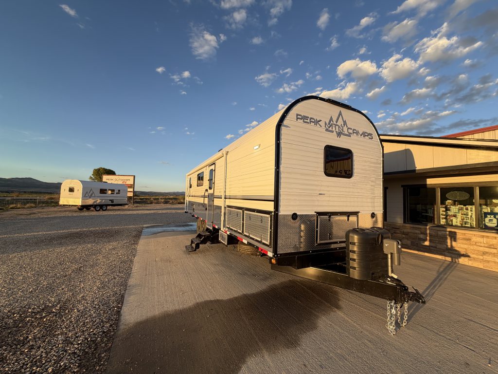 Front angled exterior showing the window, logo, and towing assembly in Keulen Camp #132.
