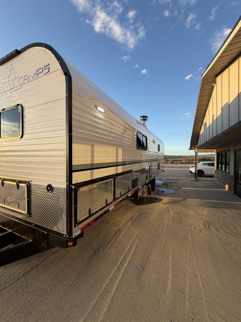 Full service-side angle with illuminated wall light and lower access panels in Keulen Camp #132.