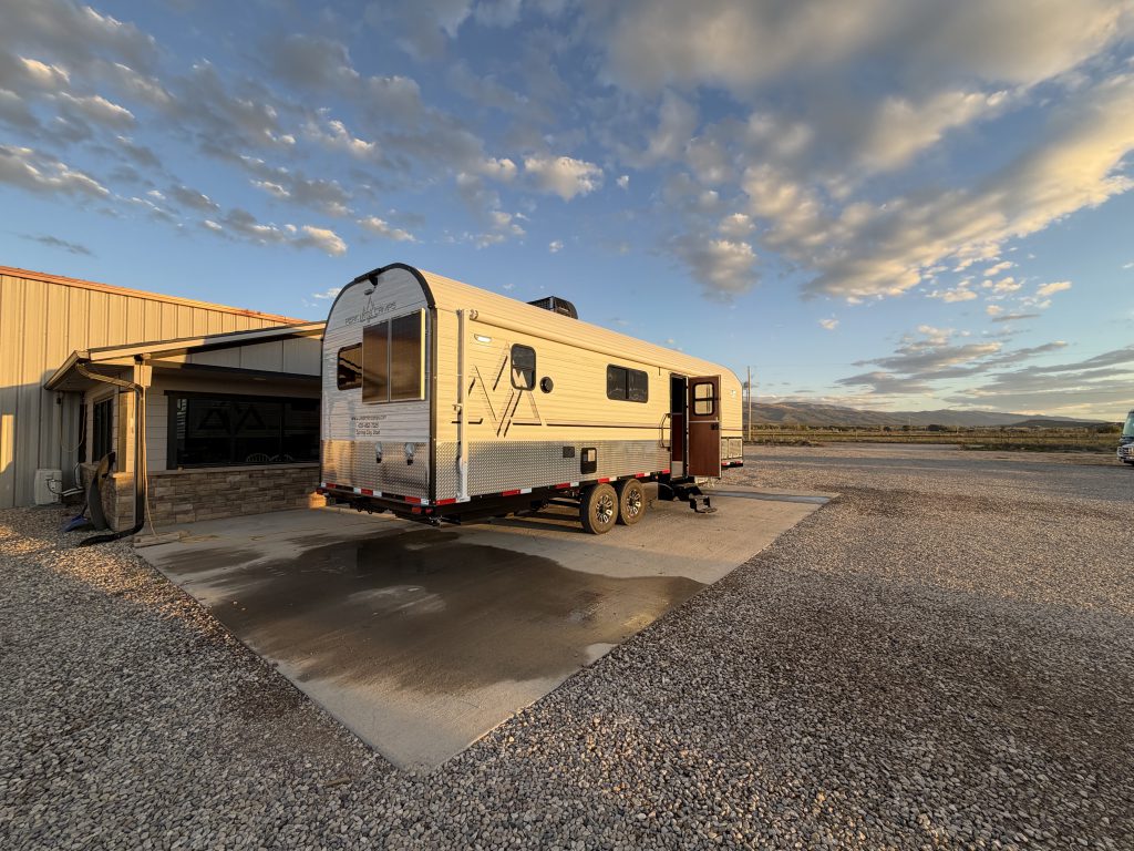 Rear entry-side exterior with door, windows, and tandem wheels in Keulen Camp #132.