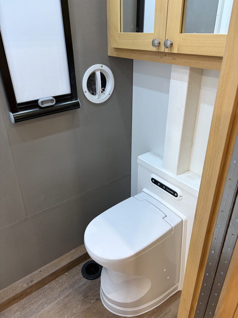 Van Niewkoop Camp #136: Cinderella incinerating travel toilet beneath the mirrored medicine cabinet.
