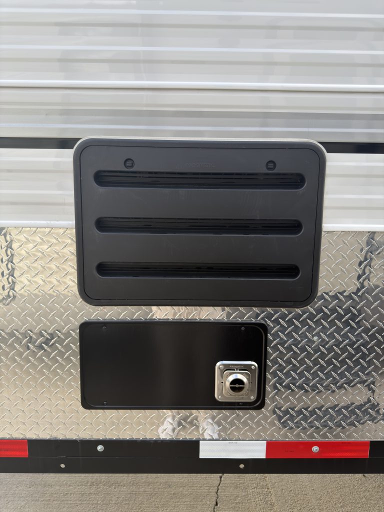 Van Niewkoop Camp #136: Exterior refrigerator vent above the furnace exhaust vent on the roadside wall.