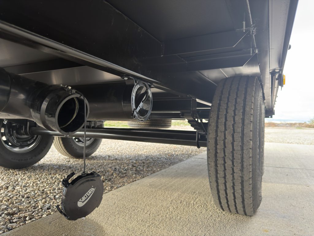 Van Niewkoop Camp #136: Underbody sewage hookup with the drain cap hanging beside the axle and tire.