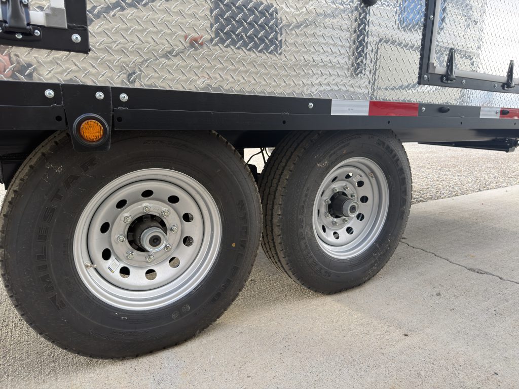 Van Niewkoop Camp #136: Tandem trailer wheels with 8-lug, 16-inch rims beneath the diamond-plate wainscot.