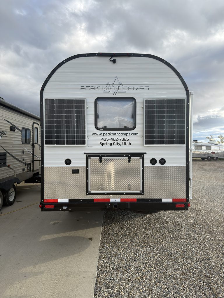 Van Niewkoop Camp #136: Straight rear view with two 100-watt solar panels flanking the egress window above the storage hatch.
