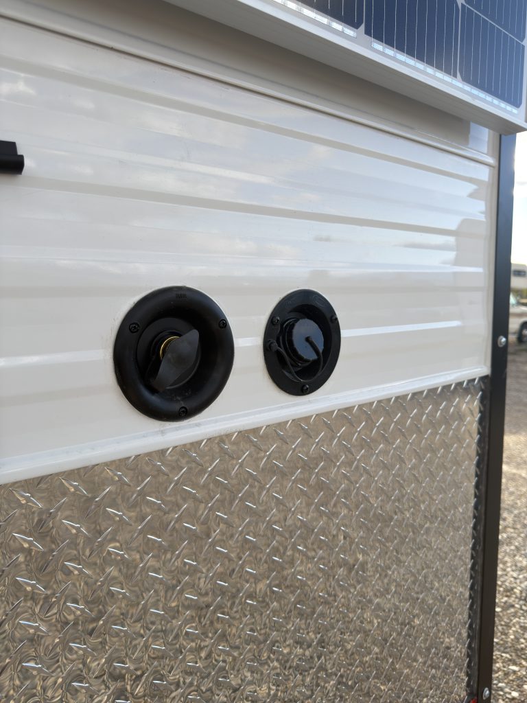 Two round service connections on the exterior side wall in Van Niewkoop Camp #136.