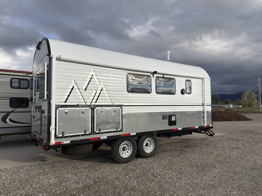 Wide angled view of the camp exterior in the gravel lot in Van Niewkoop Camp #136.