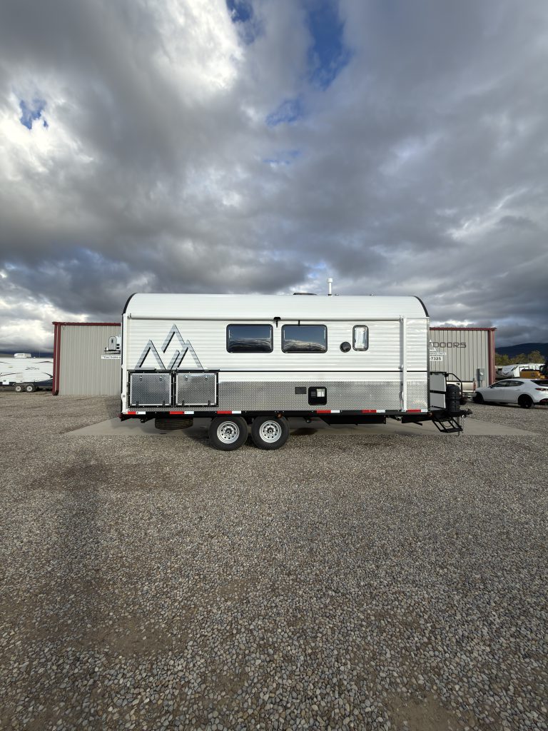 Full side profile showing windows, exterior storage, and tandem axles in Van Niewkoop Camp #136.