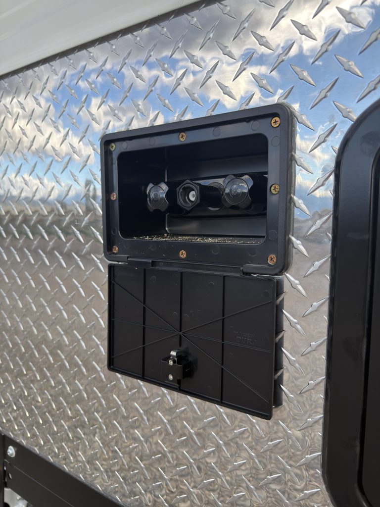 Van Niewkoop Camp #136: Close view of the exterior shower connection panel and its protective housing.