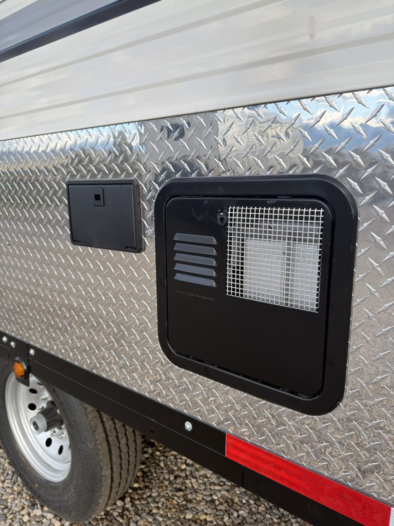 Van Niewkoop Camp #136: Black exterior vent panel beside the tandem wheels.