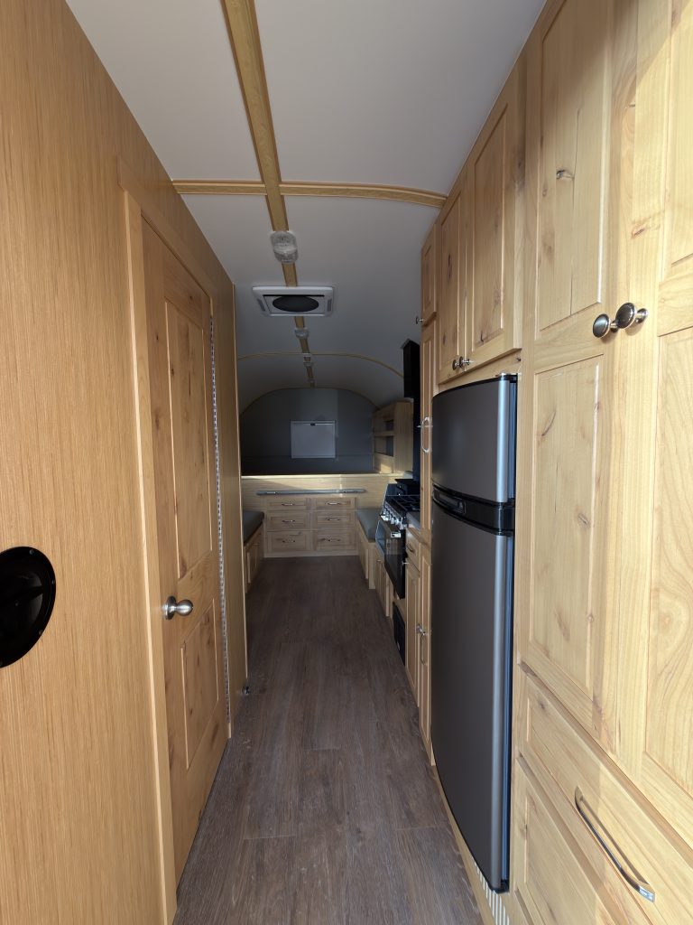 Van Niewkoop Camp #136: View down the center aisle toward the rear bed and interior cabinetry.